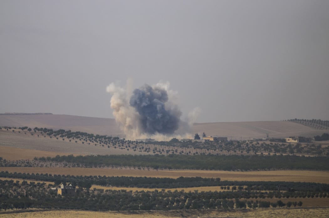The photo taken from Karkamis district of the Turkey's Gaziantep province shows smoke rising as the Turkish fighter jets bomb Daesh targets in Jarabulus, Syria on August 24, 2016.