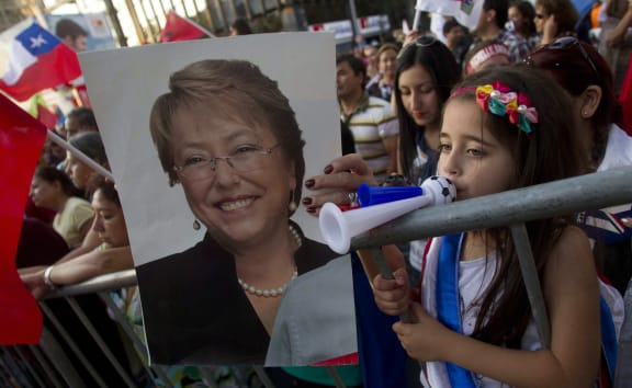 A supporter holds up a poster of new Chilean president Michelle Bachelet.