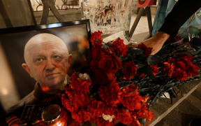 A man lays flowers at the makeshift memorial in honor of Yevgeny Prigozhin and Dmitry Utkin, who managed Wagner's operations and allegedly served in Russian military intelligence, in Moscow, on August 24, 2023.