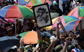 A protester holds a picture of King Bhumibol Adulyadej during Saturday's rally.