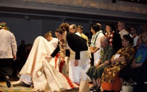 A mat is put over Prime Minister Jacinda Ardern as part of the Ifoga protocol.