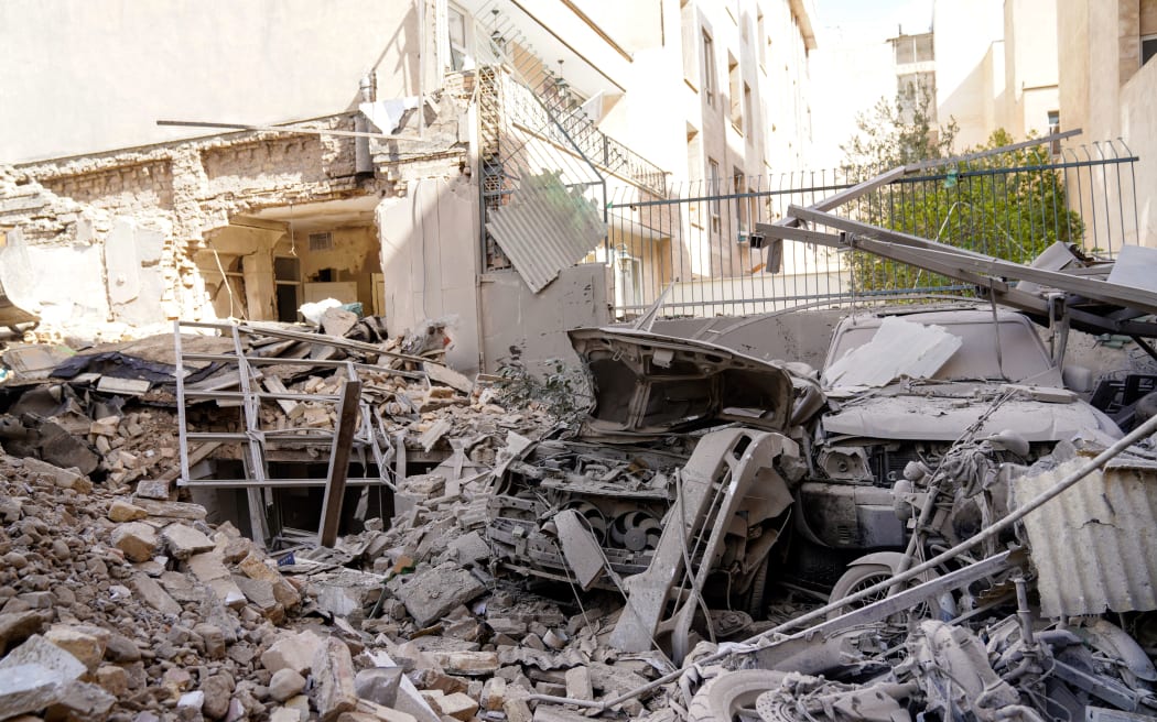 This picture obtained from Iran's ISNA news agency, shows the rubble and debris covering destroyed vehicle following a missile strike on a neighborhood of the Iranian capital Tehran on February 28, 2026. The United States and Israel launched strikes against Iran on February 28, with the Iranian Red Crescent reporting on February 28 evening, that at least 201 people were killed and 747 wounded in the strikes. (Photo by AMIR KHOLOUSI / ISNA / AFP)