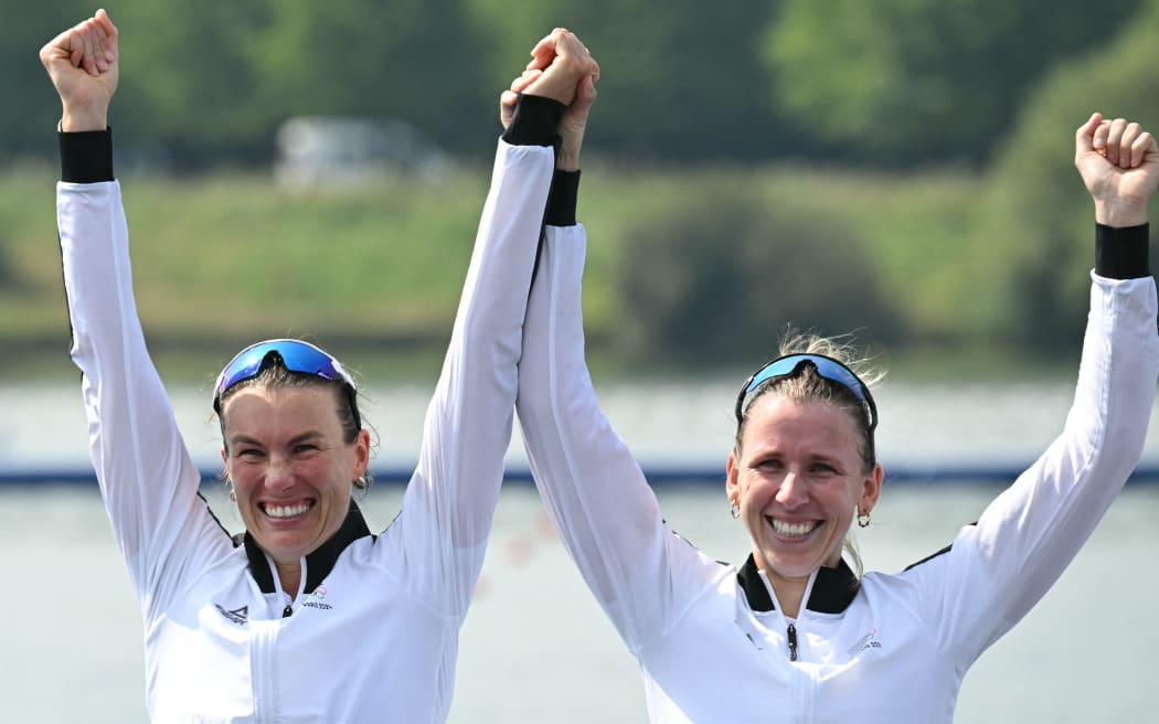New Zealand's gold medallists Brooke Francis (R) and Lucy Spoors celebrate on the podium during the medal ceremony after the women's double sculls final rowing competition at Vaires-sur-Marne Nautical Centre in Vaires-sur-Marne during the Paris 2024 Olympic Games on August 1, 2024. (Photo by Bertrand GUAY / AFP)