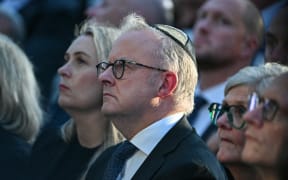 Australia's Prime Minister Anthony Albanese (C) and his wife Jodie Haydon (L) attend the memorial held for the victims of a shooting at Bondi Beach in Sydney on December 21, 2025. A father and his son are accused of spraying bullets into the family-thronged Hanukkah celebration at Sydney's most famous beach on December 14, allegedly inspired by "Islamic State ideology". (Photo by Saeed KHAN / AFP)