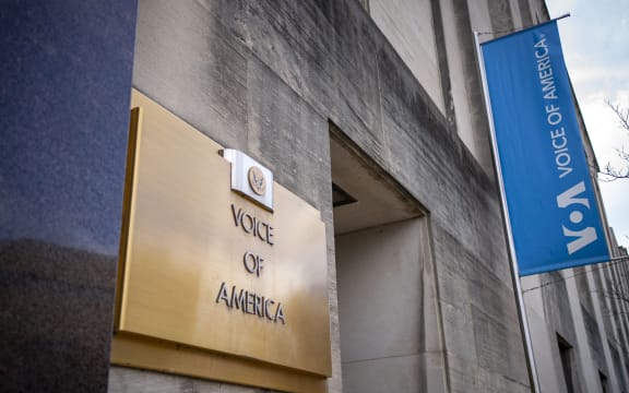 Signage for US broadcaster Voice of America is seen in Washington, DC, on March 16, 2025. US President Donald Trump's administration on March 15 put journalists at Voice of America and other US-funded broadcasters on leave, abruptly freezing decades-old outlets long seen as critical to countering Russian and Chinese information offensives. (Photo by BONNIE CASH / AFP)