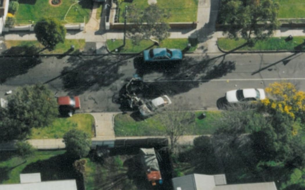 John Furlan's exploded car is seen on a residential street during the day.
