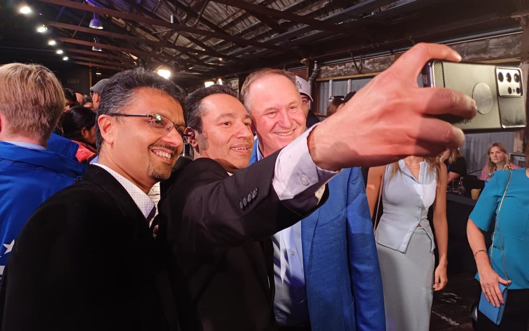 Former Prime Minister John Key greets party supporters during the National election night event.