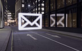 Glowing email icon in street at night, London UK