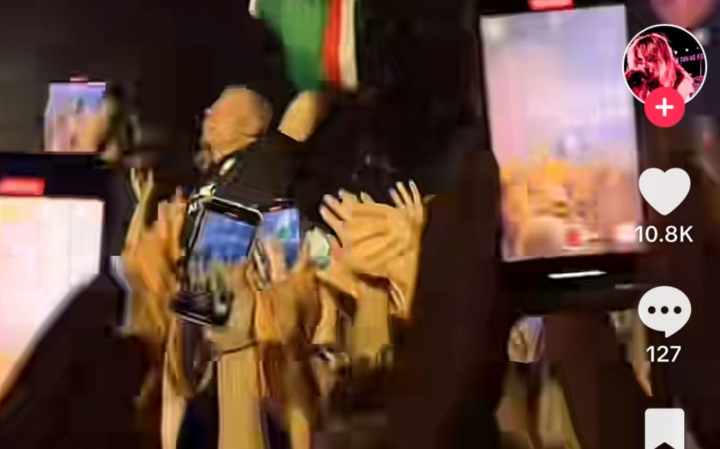 Macklemore at Spark Arena waving a Palestinian flag.