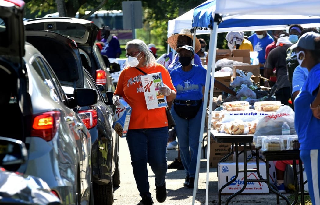 Volunteers distribute food from the Second Harvest Food Bank of Central Florida at Carter Tabernacle Christian Methodist Episcopal Church on August 8, 2020 in Orlando, Florida.