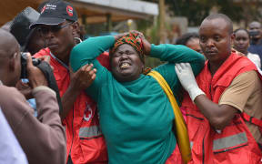 Red Cross members comfort a relative of one of those killed in the attack.