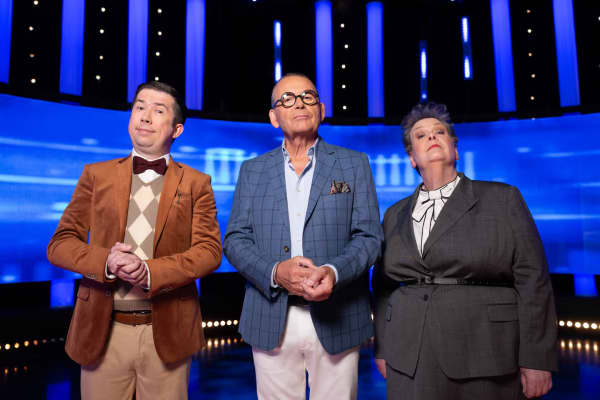 Paul Henry - in a blue suit jacket and black-rimmed glasses - is flanked by a brown-jacketed Issa Schultz and a black-jacketed Anne Hegerty.
