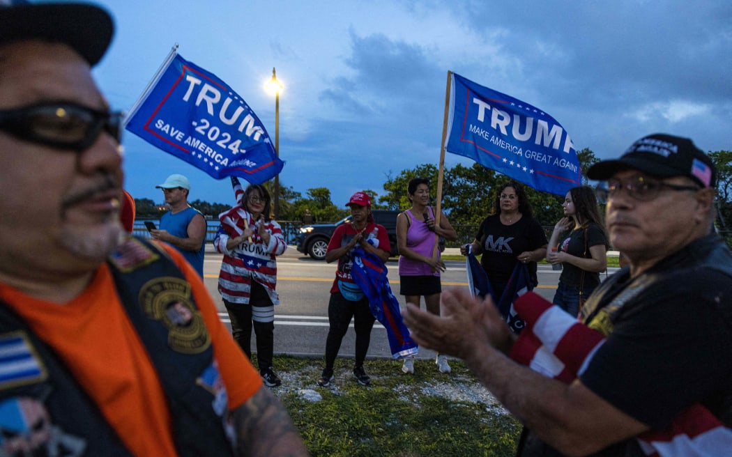 Supporters of former Donald Trump wave flags, outside his Mar-a-Lago property on Palm Beach, Florida, following the events at the Butler rally, on 13 July, 2024.