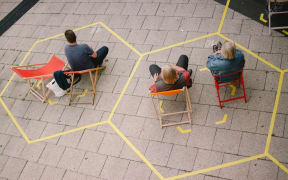 Spectators at an open air concert in Cologne, Germany, sit within social distancing markings on 23 July 2020.
