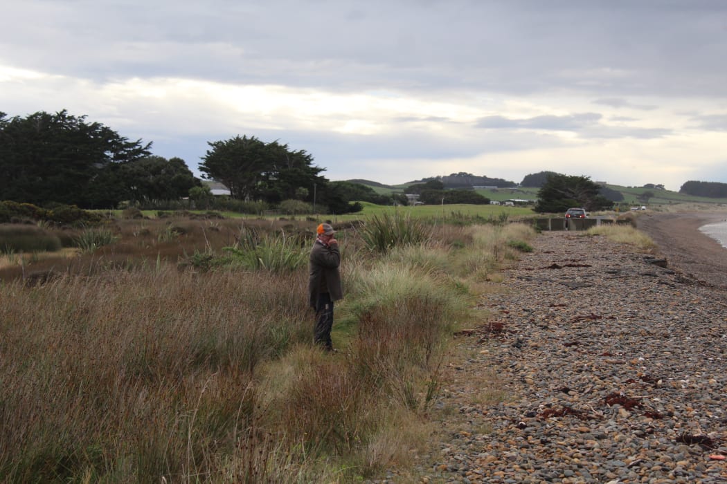 Alan McKay stands in the site of an old tip, located just meters from the crumbling road.