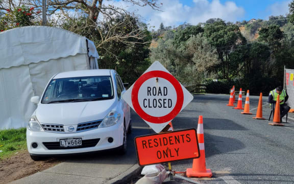 A car next to a 'road closed - residents only' sign.