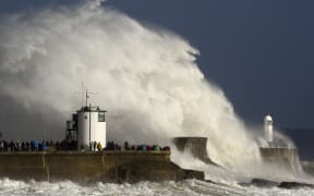 Huge waves strike the harbour wall and lighthouse at Porthcawl, South Wales, as storm Ophelia hits.