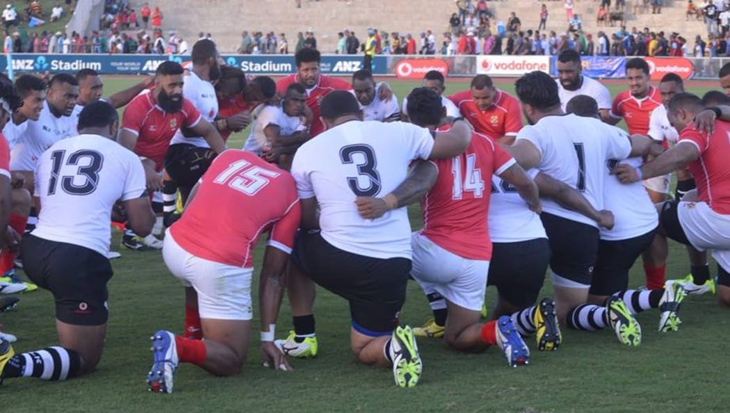 Fiji and Tonga players join together in prayer post-match.