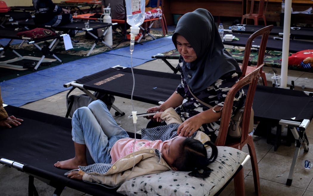 Salwa Nur Azmi, an elementary school student gets treatment in a makeshift clinic whilst she is suffering from food poisoning, after eating at the government’s free meal programme, in Bandung, West Java, on 23 September, 2025.