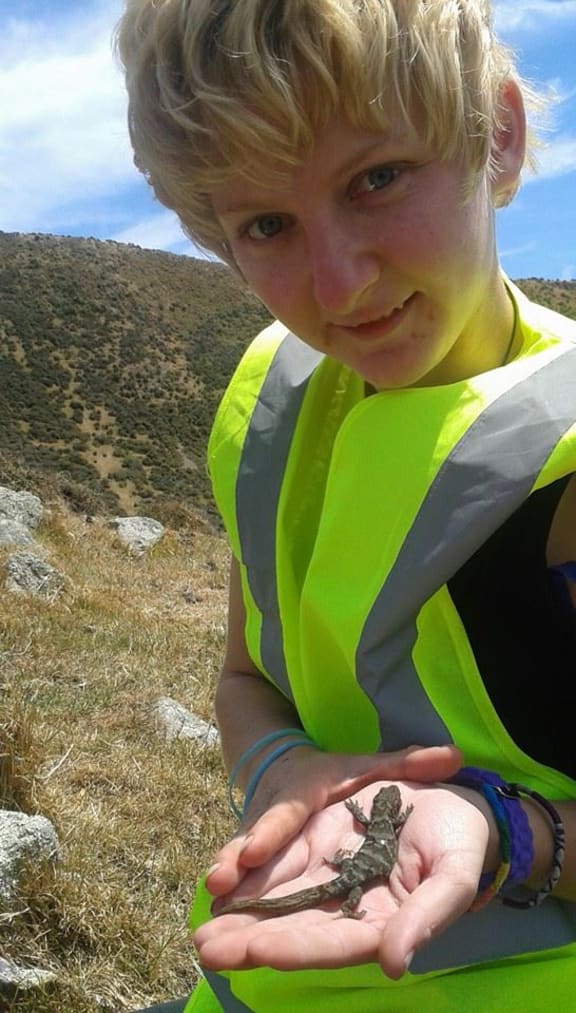 Ayla Wiles with a raukawa gecko at Baring Head.