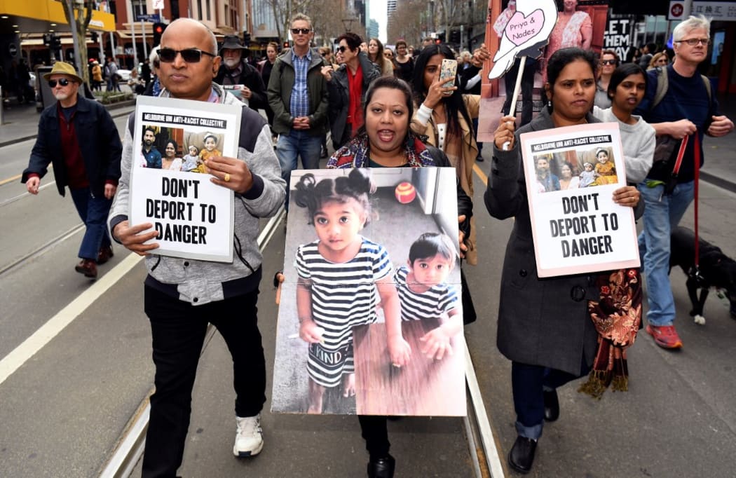 Protesters holds up placards in Melbourne on September 1 during a rally in support of a Tamil refugee family of four -- including two Australian-born toddlers -- who have been moved to the remote Australian detention centre on Christmas Island.