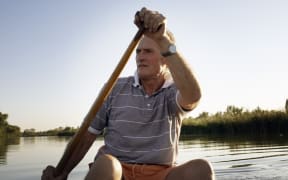 A man in a canoe, not wearing a lifejacket.