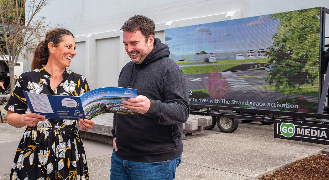 Whakatāne District Council senior policy planner Deb Ganley chats with Whakatāne Online Retailers page creator Jason Lougher, the two have been discussing the local retailers’ response to the council’s consultation document. A large screen showing potential ideas for the CBD is in the background.