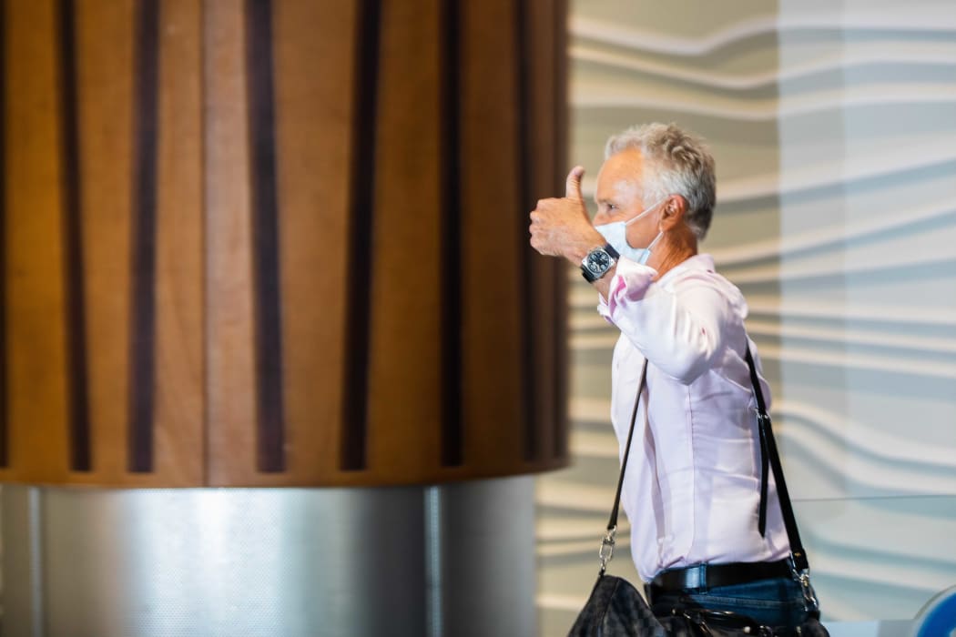 A passenger gives a thumbs-up as he walks into the arrivals hall after flying from Sydney to Auckland Airport.