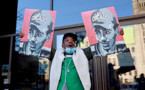 A demonstrator holds images of Daunte Wright outside the Hennepin County Government Center in Minneapolis, Minnesota, on 23 December.