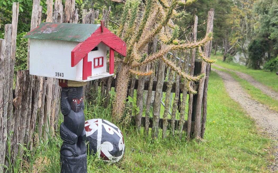 A letterbox shaped like a whare.