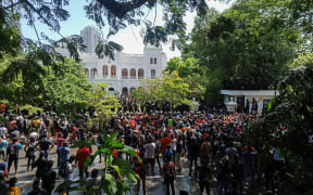 Demonstrators take part in an anti-government protest outside the office of Sri Lanka's prime minister in Colombo on July 13, 2022. - Sri Lankan police fire tear gas to hold back thousands of demonstrators mobbing the premier's office in Colombo on July 13, AFP reporters at the scene saw. (Photo by AFP)
