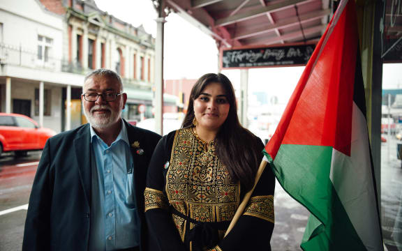 (L-R) Sameer and Wajd stand on the street with the Palestinian flag