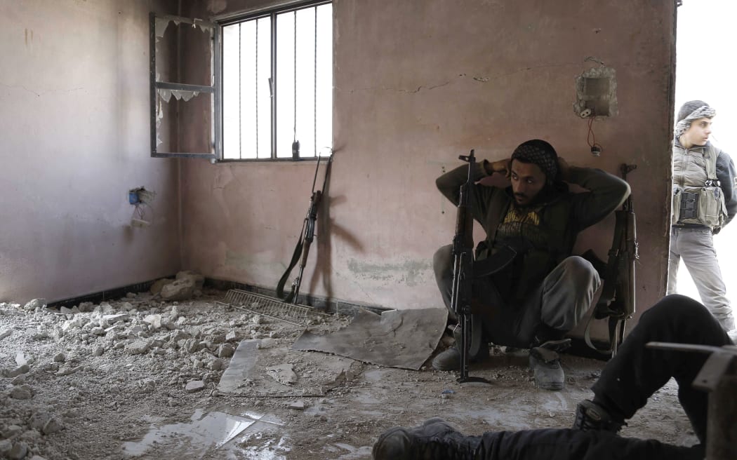Syrian rebels take a break as they hide from regime forces in Bala on the Damascus outskirts. Major players in Syria's war traded accusations over violations of the first major ceasefire in the five-year conflict, but the truce remained largely intact on its second day.