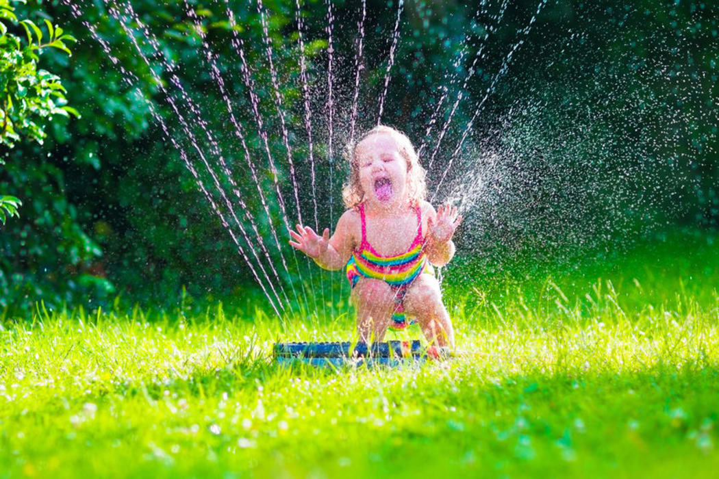 Child playing in a sprinkler