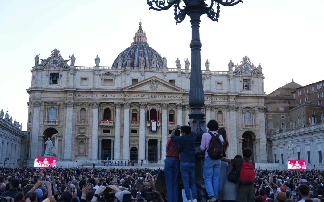 People listen to newly elected Pope Robert Francis Prevost, Pope Leo XIV, addresses the crowd from the main central loggia balcony of the St Peter's Basilica for the first time, after the cardinals ended the conclave, in The Vatican, on May 8, 2025. Robert Francis Prevost was on May 8, 2025 elected the first pope from the United States, the Vatican announced. A moderate who was close to Pope Francis and spent years as a missionary in Peru, he becomes the Catholic Church's 267th pontiff, taking the papal name Leo XIV. (Photo by Dimitar DILKOFF / AFP)