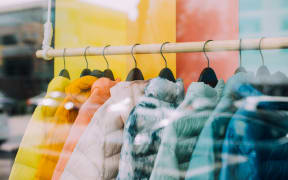 Colourful jackets displayed in a shop window.