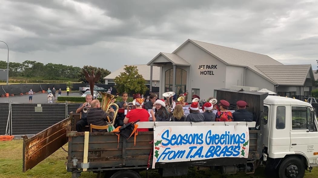 Musicians play some music for guests at Hamilton's Jet Park Hotel to cheer them up on Christmas.