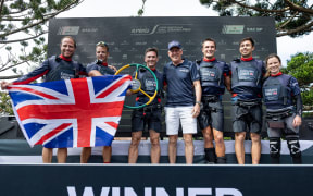 Luke Parkinson, flight controller of Emirates Great Britain SailGP Team, Nick Hutton, grinder of Emirates Great Britain SailGP Team, Dylan Fletcher, driver of Emirates Great Britain SailGP Team, Martin Sheppard, National Chairman - KPMG Australia, Neil Hunter, grinder of Emirates Great Britain SailGP Team, Iain Jensen, wing trimmer of Emirates Great Britain SailGP Team, and Hannah Mills, strategist of Emirates Great Britain SailGP Team, on the podium after Emirates Great Britain SailGP Team win the final race on Race Day 2 of the KPMG Australia Sail Grand Prix in Sydney, Australia. Sunday 9 February 2025. Rolex SailGP Championship Event 3 Season 2025. Photo: Patrick Hamilton for SailGP. Handout image supplied by SailGP