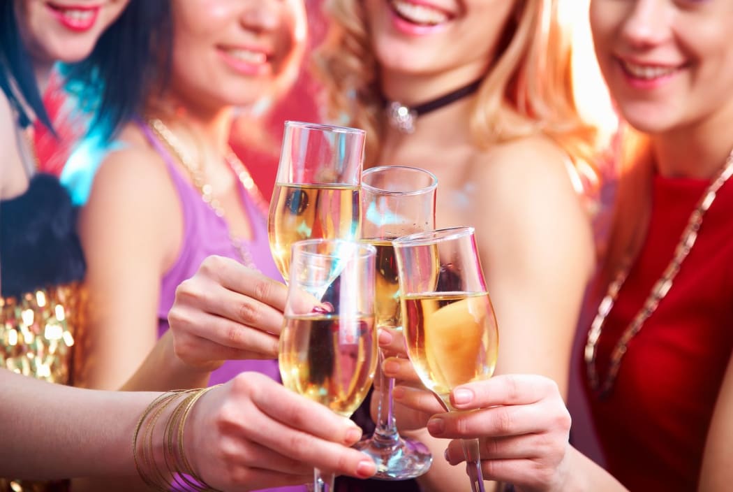 Women clink glasses of champagne at a party