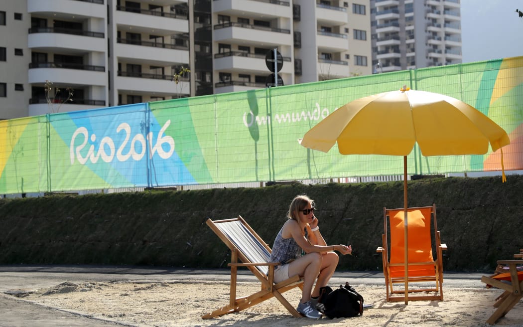 A visitor talks on mobile phone at a fake beach on the entrance of The Olympic Village on Barra da Tijuca neighboorhood, in Rio de Janeiro.