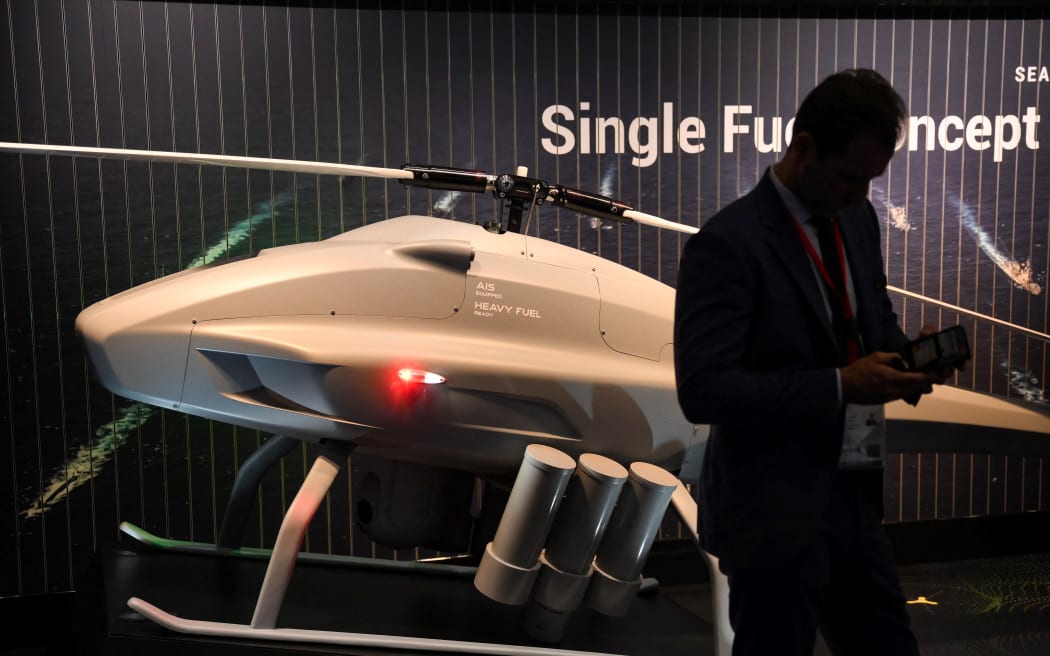 An expo attendee in front of a drone displayed at the Defence and Security Equipment International (DSEI) fair in London, on 12 September, 2023.