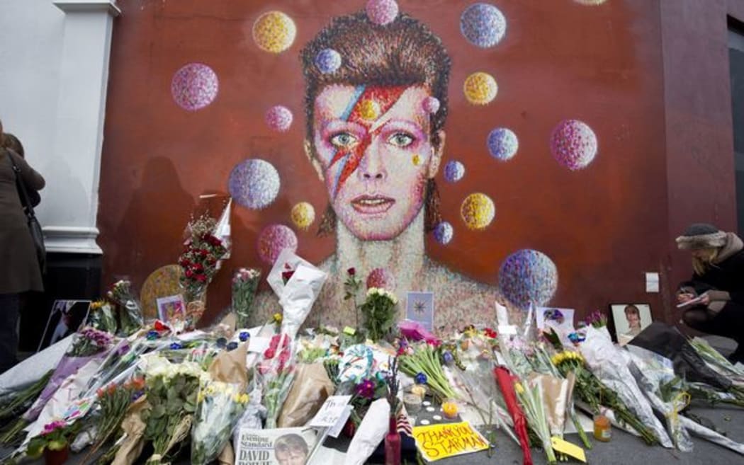 Flowers and tributes are left beneath a mural of David Bowie painted by Australian street artist James Cochran, aka Jimmy C, in Brixton, South London.