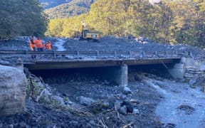 Crews working to remove over 20,000 cubic meters of slip material from the Muddy Creek bridge on the Haast Pass.