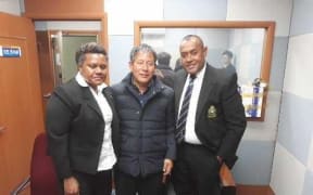 Former church member Yoon-jae Lee with two Fijian police officers