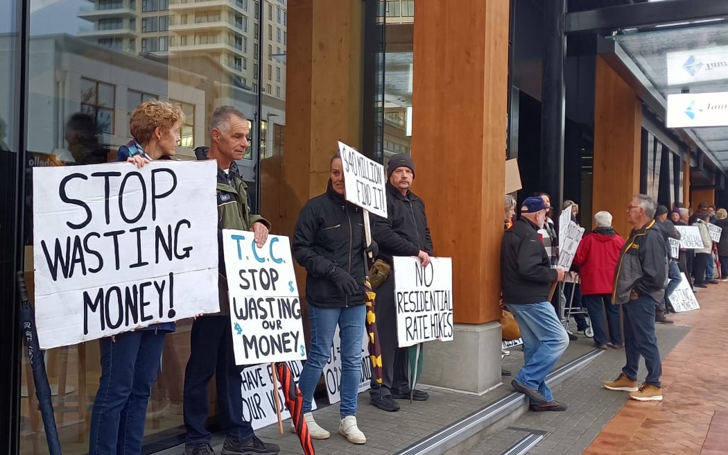 Some of the 60 people that gathered outside the Tauranga City Council building to protest the 9.9% rates increase on Thursday morning.