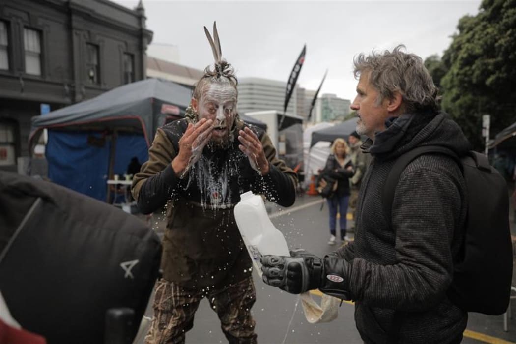 A protester washes their face with milk - something used to cool the effects of pepper spray.