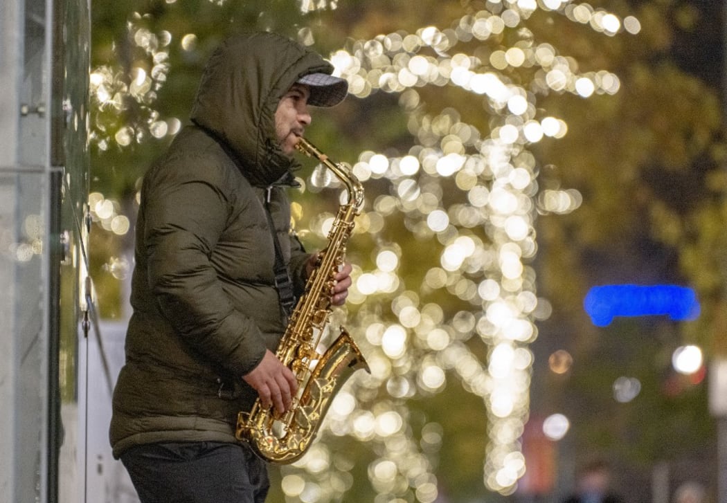 A man plays his saxophone at a Christmas market in front of Vienna's city hall in Vienna, Austria on November 19, 2019. (Photo by JOE KLAMAR / AFP)