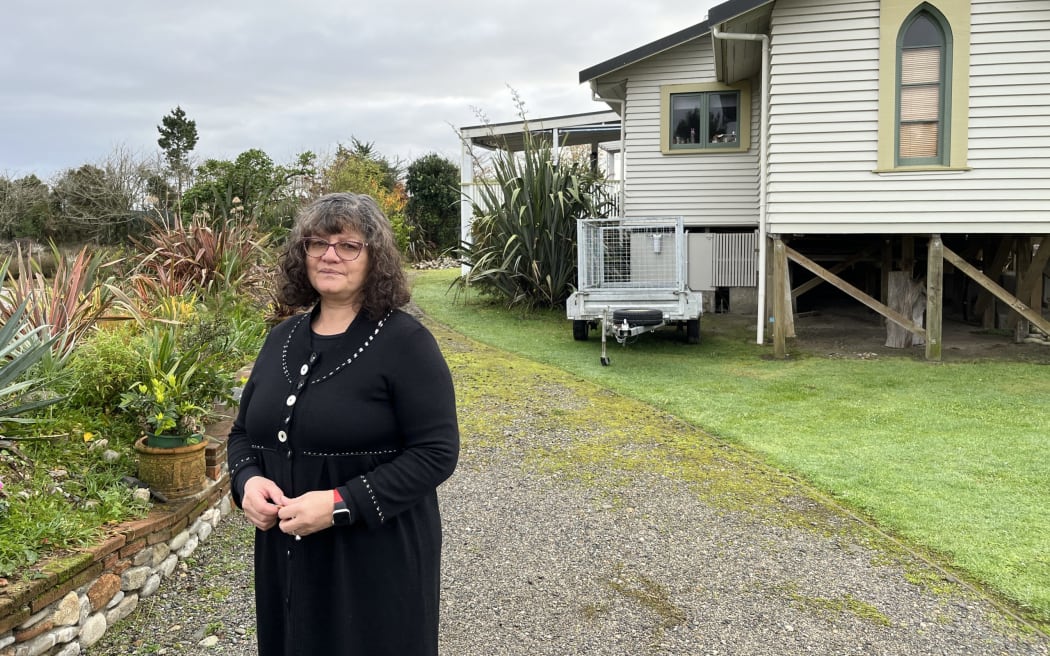 Ruth Vaega outside her Snodgrass Road home in June 2022. The house was raised onto higher foundations following Cyclone Fehi in February 2018 but now may be abandoned -- its owners are no clearer two years on from the July 2021 flood.