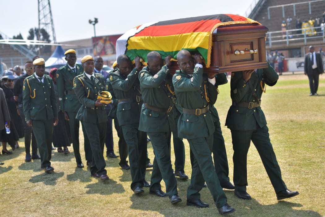 Soldiers in ceremonial uniform carry the casket of Zimbabwe's former President, the late Robert Mugabe after it arrived at Rufaro stadium on September 13, 2019.