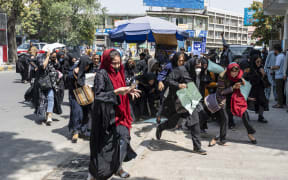 Taliban fighters fire into the air to disperse Afghan women protesters in Kabul on August 13, 2022. - Taliban fighters beat women protesters and fired into the air on Saturday as they violently dispersed a rare rally in the Afghan capital, days ahead of the first anniversary of the hardline Islamists' return to power. (Photo by Wakil KOHSAR / AFP)